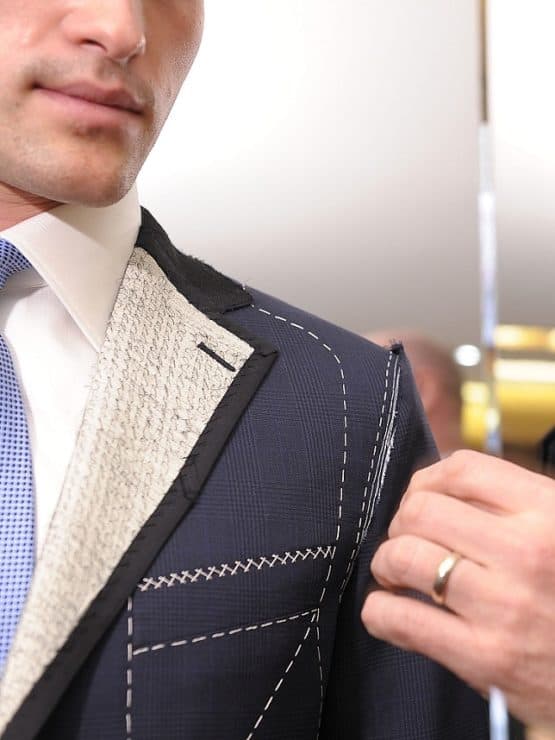 Close-up of a hand-basted suit lapel during a fitting